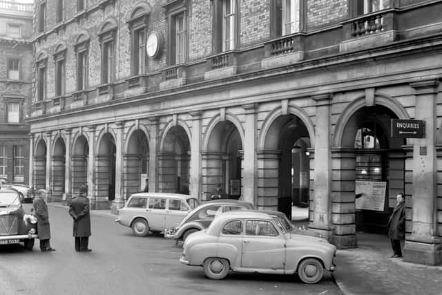 Exterior of the original Birmingham New Street Station, designed by William Livilock and built in 1854 to serve both the London and North Western and Midland Railways. A policeman stands watch over several parked cars. A complete redevelopment of the station was carried out in the 1960s.