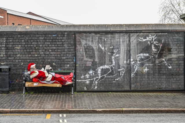 Father Christmas has showed up on a bench in Birmingham's Jewellery Quarter next to the Banksy mural. December 17 2025.