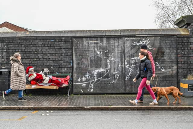 Father Christmas has showed up on a bench in Birmingham's Jewellery Quarter next to the Banksy mural. December 17 2025.