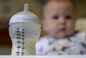 File photo dated 20/11/23 of a baby in a high chair looking towards her bottle of milk in the foreground (Andrew Matthews/PA)