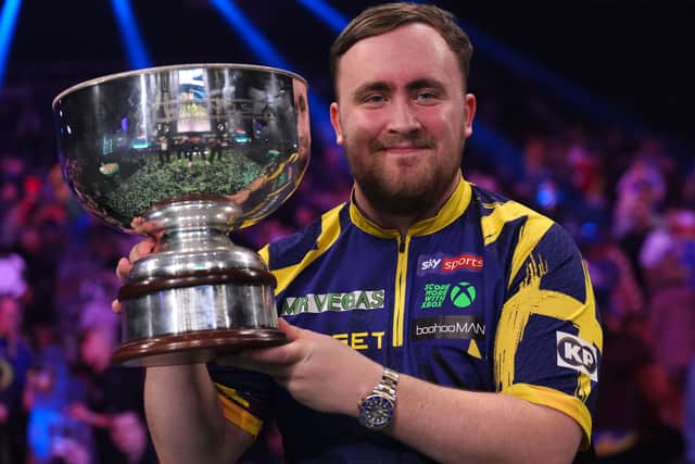 Littler lifts the trophy after winning the Grand Slam of Darts final in Wolverhampton (Martin Rickett/PA)