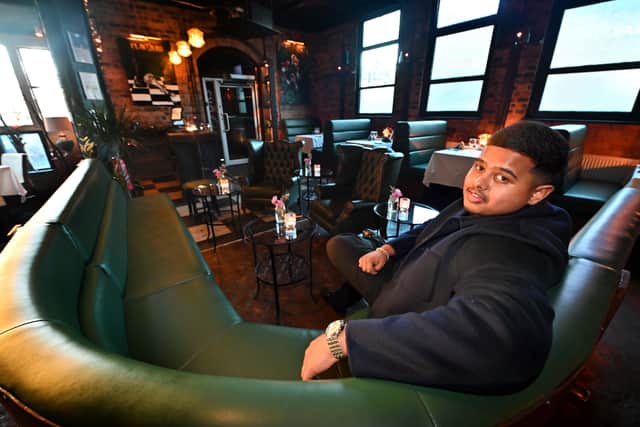 Sameen Ali, 20, relaxes in the dining room of his new restaurant
