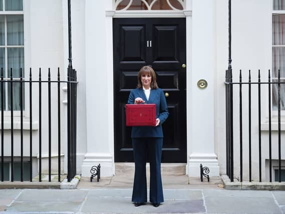 Rachel Reeves holds her ministerial red box up outside the door of 11 Downing Street