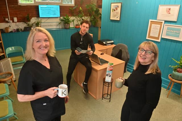 K with musculoskeletal clinician George Cater and receptionist Julie Simpson.