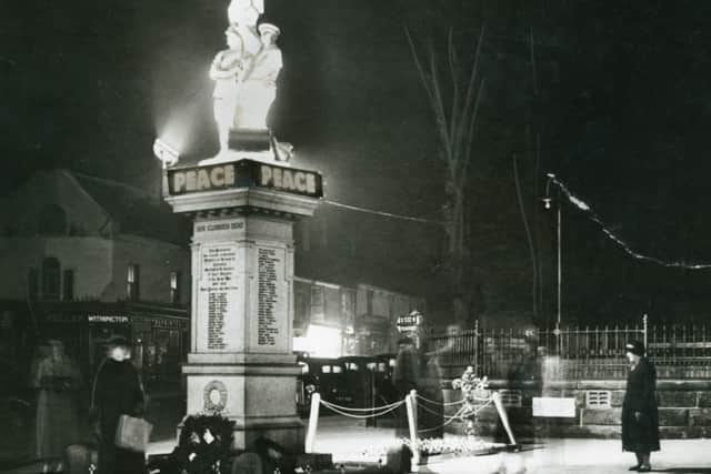 Visitors pay respects as Cannock War Memorial is illuminated for Armistice Week, in November 1938