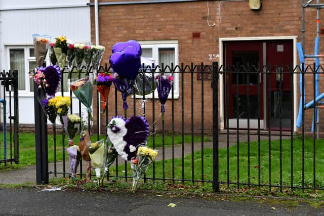 Tributes of flowers and balloons sit at the scene where a 30-year-old man was left dead