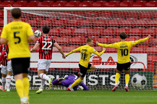Elliot Newby turns to celebrate after opening the scoring for Barrow.