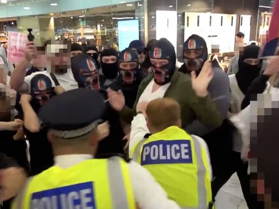 Video grab image issued by the Metropolitan Police of a clash between masked demonstrators and officers during an anti-illegal immigration protest in a Canary Wharf shopping centre