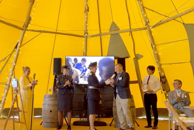 Tracey Lockley from Mobell, left, with an RAF cadet, Professor Liz Barnes - the Lord Lieutenant of Staffordshire, presenting a Scroll to Ben Warke, with chairman Vince Owen, seated right