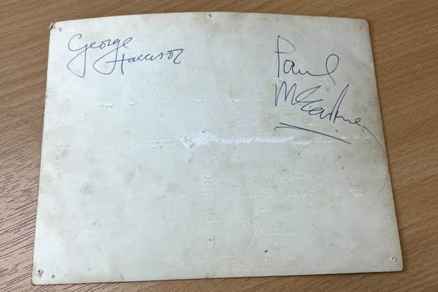 George Harrison and Paul McCartney signed their signatures on the back of the image