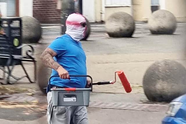 Two men wearing St George's masks have been captured on camera painting England flags on roundabouts and zebra crossings across a town.