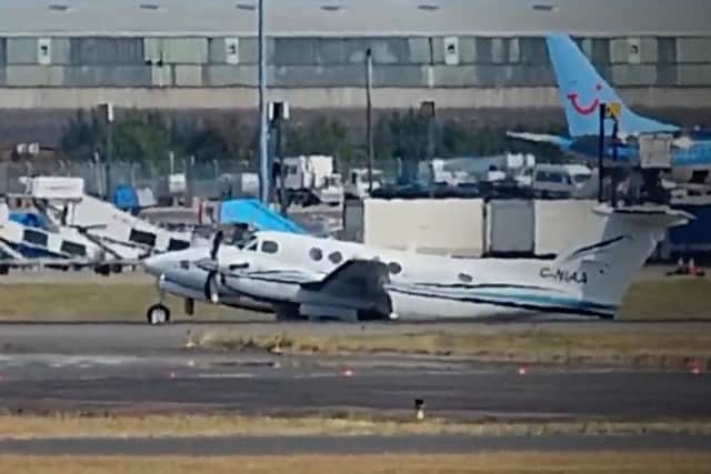 Plane drags along the runway at Birmingham Airport after making an emergency landing.