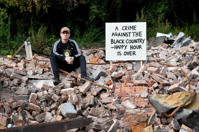 Artist Dion Kitson painted the signs erected in the rubble at the Crooked House