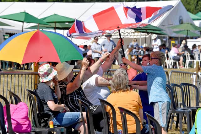 Attendees staying in the shade from the heatwave sun.