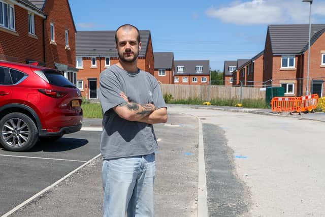 Charlie Brayson standing on unfinished pavment on Buckthorn Drive at Hollington Grange estate in Stoke-on-Trent.
