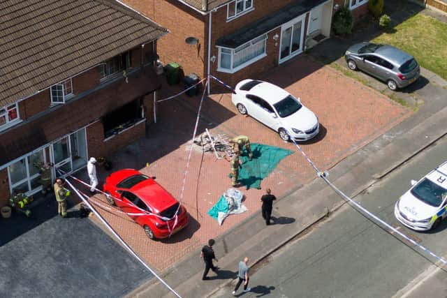 Police and forensics officers at the scene of a burnt-out house in Plascom Road in Wolverhampton