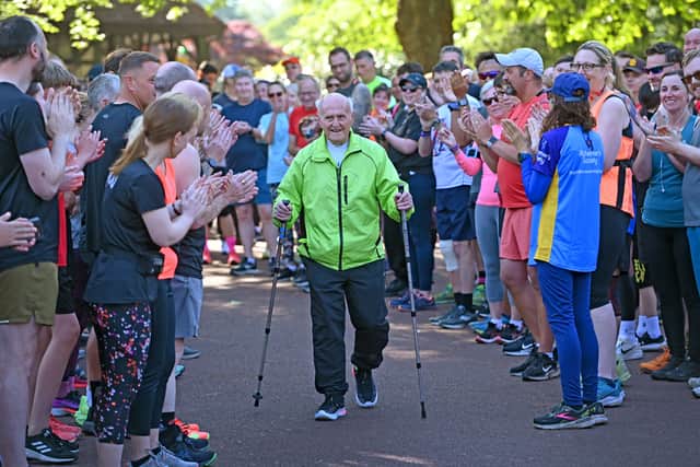 Clive Jukes is cheered on by friends and fellow runners as he heads to the start line