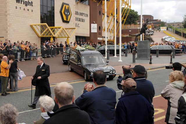 Fans gather outside Molineux Football ground to pay their last respects to footballing legend Derek Dougan after his funeral service at St Peter's Church, Wolverhampton.