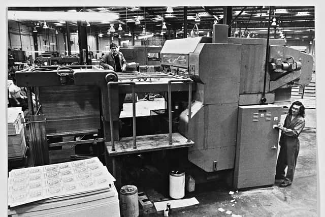 Tony Taylor (top) and John Williams working with the cutting and creasing machine at Baldwins, box and carton makers, 1978