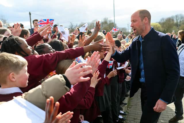 The Prince of Wales high fives schoolchildren from Fibbersley Park Primary Academy.