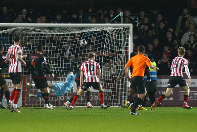 Jordan Thomas rifles a deflected shot past Tommy Simkin to equalise for Cheltenham.