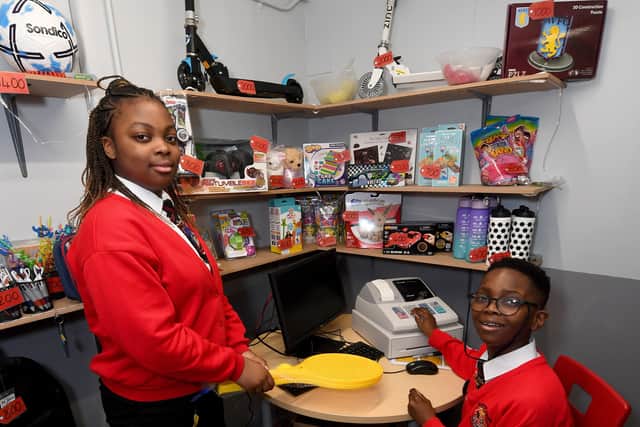 Zayah Obakpolor, aged 11, and Bukunmi Ibileye, aged 10, at the school's 'bank'