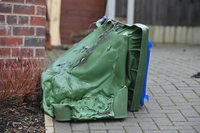 A green rubbish bin appears to have melted as a result of the fire