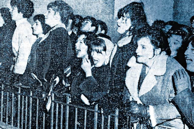 Beatles fans jockeying for a glimpse of the group outside the Gaumont Cinema