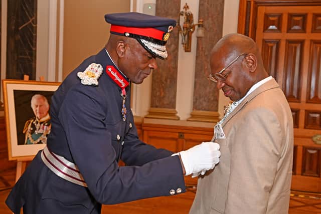 Christian Dixon being given his BEM by Lord-Lieutenant Derrick Anderson..