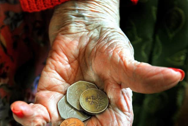 An elderly woman holding some money. 