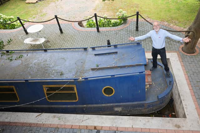 Steven Cuddy with the mini canal lock he built to house a narrowboat turned into a swimming pool on a plot next to his hotel in Coleshill - the barge can travel up to 24 inches