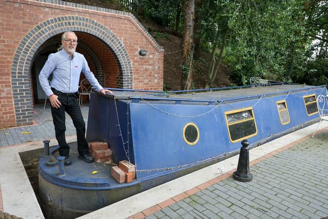 Steven Cuddy with the mini canal lock he built to house a narrowboat turned into a swimming pool on a plot next to his hotel in Coleshill - the barge can travel up to 24 inches.