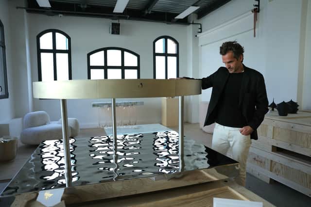 French designer Mathieu Lehanneur poses with the cauldron he designed for the flame during the Paris Olympics games, in his workshop in Ivry-sur-Seine, France.