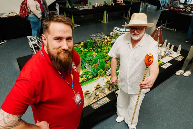 Paul Clark and Mark Hallbury pose next to Jurassic Park