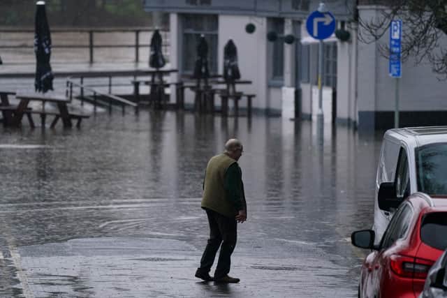 A man walks by flooded roads in Worcester after heavy rain. Photo: Jacob King/PA Wire.