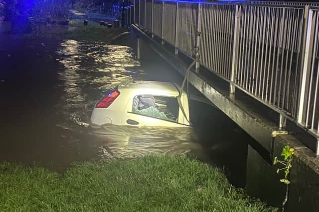 The car trapped in fast-flowing water in Hall Green. Credit: West Midlands Police.