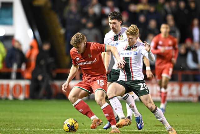 Freddie Draper protects the ball from two Wrexham players  (Owen Russell)