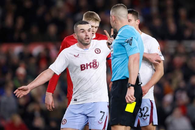 Referee Robert Jones gestures to Aston Villa's John McGinn