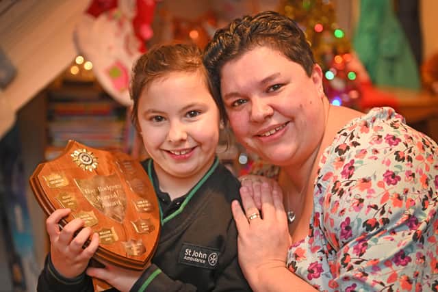 Millie Turner, aged 8, with her mum Pamela and Millie's St John Badger Award
