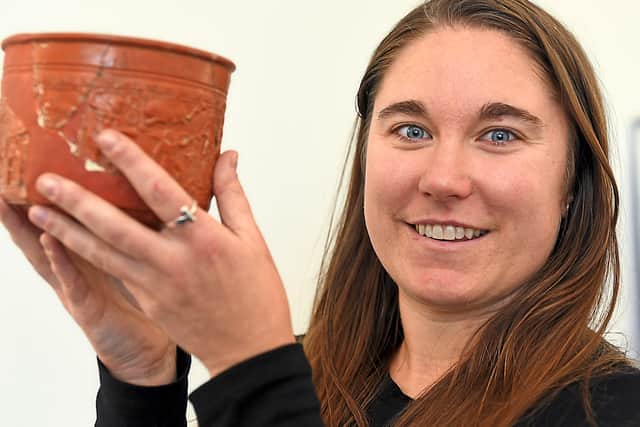 Collections project officer Katie Miller with a piece of Roman pottery