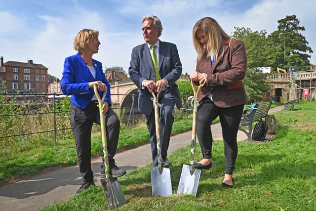 The ground breaking begins with all three participants getting their shovels stuck in