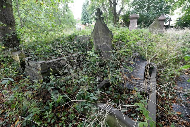 Residents near St John's Church, Dudley, are angry about the state of the cemetery. Judith Fisher next to an overgrown gravestone