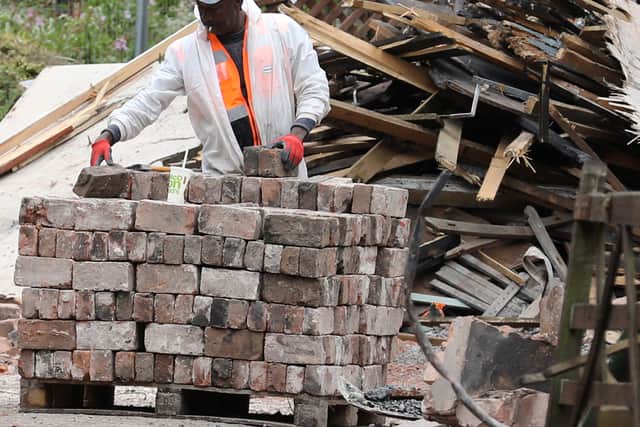 Workers stack bricks at the Crooked House site in Himley