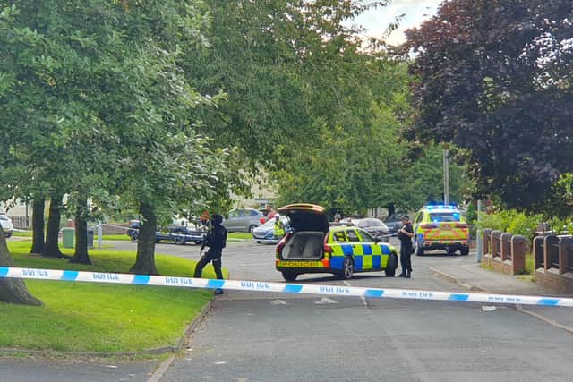 Armed officers keep an eye on the area around the flats
