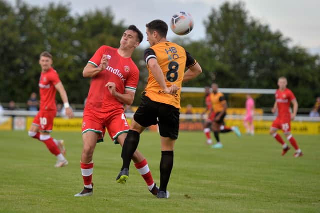 Walsall's Oisin Mcentee goes up for a header with Leamington's Adam Walker