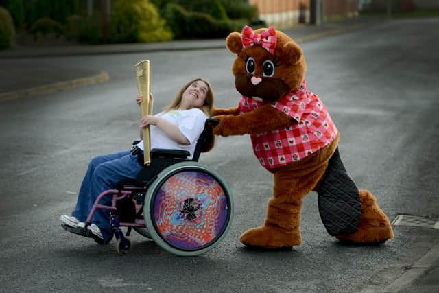 Ceri with the Olympic torch and mascot Banofie Beaver