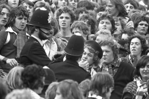 Police break up a scuffle in a crowded Loftus Road in London, where QPR were playing Liverpool.