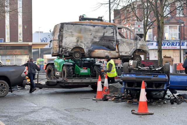 A burnt out van has finished for the day, and is being cleared off the set.