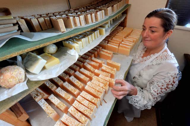 Karen with soaps that are curing, some for up to six weeks