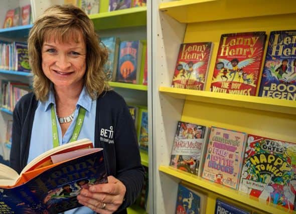 Pictured with The Book of Legends by Sir Lenny Henry is Dudley Library staff member, Sally Cartwright